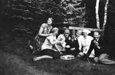 Sex kvinnor och en yngling poserar glatt med en kaffebricka i en skogsdunge. Den unge mannen håller upp en så kallad Marboring - en kaka typisk för Mark och trakterna däromkring.
