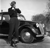 Fotografen Kerstin Bernhard står bredvid en bil tillsammans med sin tax