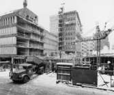 I förgrunden byggs huset Rådmansgatan 65, vari postverkets läkarcentral skall inrymmas. I fonden Postbankshusets centrumdel.