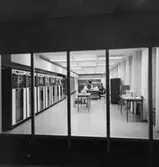 Postbankens Datacentral i våningen 3 trappor. Belägen utmed Drottninggatan. Dataanläggningen sedd genom fönstervägg från ett undervisningsrum.