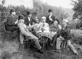 Midsommarfirande i Lindås 1893. Männen Artur Eneström, Alfred Larsson, C.A. Eriksson, Ade Sandberg, Albert Andersson, Petter Sandberg och Lionel Eneström sitter vid ett bord och dricker.