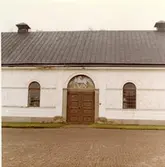 Kolbäck sn, Strömsholm.
Ridskolan.
Del av byggnaden, med rundade fönster och skulpterat dörröverstycke.