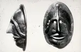 Beslag av brons i form av en ansiktsmask från romersk järnålder.