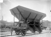 Statens Järnvägar, SJ självlossande kolvagn Q7 23021

Kolluckorna var ursprunligen plana, hängda i överkant ocg därmed lät
kolet glida i rännor på bägge sidor utanför långbalkarna.
Från 1911 till 1928 byggdes dessa kolvagnar