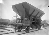Statens Järnvägar, SJ självlossande kolvagn Q7 23021

Kolluckorna var ursprunligen plana, hängda i överkant ocg därmed lät
kolet glida i rännor på bägge sidor utanför långbalkarna
Från 1911 till 1928 byggdes dessa kolvagnar