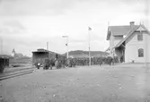 Tåg på stationen. Folksamling.