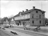 Stationen. Personal i förgrunden. Kärra för transport av gods.