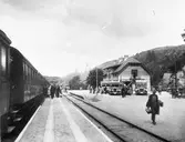 Statens Järnvägar, SJ bussar och lastbilar vid Dingle järnvägsstation. Järnvägsstationen uppfördes av SJ 1905. På spåret syns ett ångloksdraget personvagnståg.