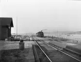 Ett ånglok med personvagnar på ingående till station