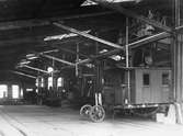 Liljeholmens järnvägsverkstaden. Fordonen är bortifrån ett Statens Järnvägar, SJ J-lok, en I-vagn, ett N-lok och C2c 444. C2-vagnen slopades 1928 och byggdes 1929 om till hjälpvagn.