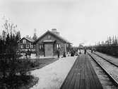 Stationen med resande och malm vagnar på sidospåret.