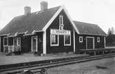 Håll- och lastplats. Envånings stationshus i trä, sammanbyggt i vinkel med godsmagasinet.