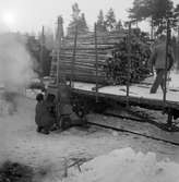 Lastning av timmer från lastbil till godsvagn med Puller timmerlastningsapparat, Glissjöberg.