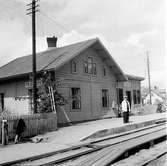 Fridafors järnvägsstation. Stationspersonal i sommaruniform. Ställbock till vänster.