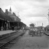 Många resande på plattformen. 
Linköpings station uppfördes mellan åren 1871-1872.