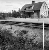 Kilometerskylt 243. Framför stationshuset står en stins.Trafikplats anlagd 1926.