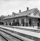 Resande står och väntar på plattformen. Stationen anlagd 1874.