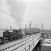 Statens Järnvägar SJ 1856-1956. 100-årsjubileum. Tåg med gamla lok och vagnar på Södra Järnvägsbron på sträckan mellan  Mälarstrand och Riddarholmen.