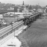 Statens Järnvägar SJ 1856-1956. 100-årsjubileum. Tåg med gamla lok och vagnar vid Södra järnvägsbron på sträckan mellan  Mälarstrand och Riddarholmen.