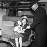 Flicka  med mamma på tåget visar barnbiljett.