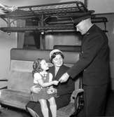 Flicka med mamma på tåget visar barnbiljett.