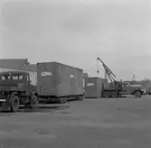 Lossning av helikopter i emballage från låglastande släpvagn, vagnbjörn