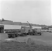 Lossning av helikopter i emballage från låglastande släpvagn, vagnbjörn