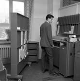 Man vid sorteringsmaskin  för hålkort, av modell IBM 83 Sorter.