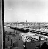 Expresståg på Riddarholmsbron, vid driftplats Mälarstrand, på väg mot Riddarholmen.  Tyska kyrkan även i bild.
Fotot möjligen taget från taket på fastighet Pryssgränd/Bastugatan.