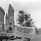 Personal vid Statens Järnvägars Resebyrå i Berlin håller upp en  informationsskylt med texten: 