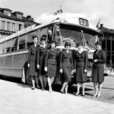 Bussvärdinnor vid Stockholms Centralstation. Scania Vabis Statens Järnvägsr SJ CF 65-61. En reklamskylt med orden 