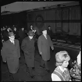 Invigning av Årsta partihandel. Kung Gustav VI Adolf, 2:a från vänster i andra raden. Generaldirektör, Gd, Erik Upmark 3:a från vänster i andra raden. Kvinnor i folkdräkt med blomsterkorgar