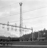 Strålkastarmast vid Tomteboda bangård. Vedeldat ånglok i bakgrunden.