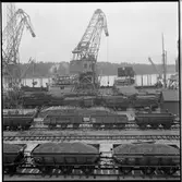 Lastning. på bangården står godståg med olika fraktgods. Trafikaktiebolaget Grängesberg–Oxelösunds Järnvägar, TGOJ M4 4185, TGOJ M4 4315, TGOJ M 3139, TGOJ M 3219, TGOJ M4 4427.