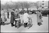 Man med cykel samtalar med järnvägspersonal. I bakgrunden syns gengasutrustade bilar.