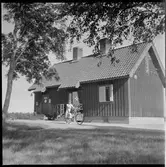 Okänd kvinna utanför ett stationshus.