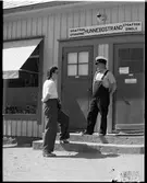 Personal och resande framför busstationen Hunnebostrand.