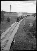 Blandat tåg draget av vedeldat ånglok någonstans på Stockholm - Västerås Bergslagens Järnvägslinjer.