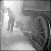 Sotning av ånglok. Asklådans innehåll har tömts.