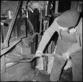 Lokeldare Viggo Kjällberg skyfflar in kol i eldstaden på ånglok.