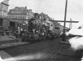 Statens Järnvägar, SJ B. Loket är utrustat med Marcottys rökförbränningsapparat vilket syns på plåtringen runt skorstenen.
Tåg 22 vid avgång från Stockholm Central station våren 1921.