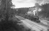 Stockholm - Västerås Bergslagens Järnväg, SWB H3 60 med tåg, rullar ut från stationen. Loket är tillverkat av Nydqvist & Holm i Trollhättan 1910. Tåget är på väg mot Tillberga.