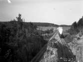 Dubbelspåret vid Bränninge tunnlarna. Ankommande tåg fotograferat från höjd.