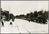 Hindås station med resande på skidor.