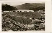 Trängslets kraftverksbygge. Fångdammen sedd från nedströmssidan med dämningssjön i bakgrunden.