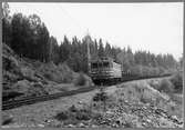 Malmtåg vid Rällså på linjen mellan Rällså och Vasselhyttan. Tfv Grängesberg - Oxelösunds Järnvägar, TGOJ Ma 406. Loket tillverkat 1954 av ASEA och Falun.