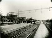 Herrljunga station öppnad 1863. Först byggdes ett litet stationshus som användes 1862 -1864. Nytt stationshus byggt 1864. UWHJ tåg tar in resande.