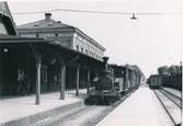 Bilden togs sommaren 1942. Station anlagd 1874. Tvåvånings stationshus i tegel. Då hette den  Karlshamn Västra. Smalspårig ånglok 12.