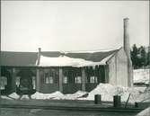 Lokstallar med snö på taket. Text på bilden - Tre nya lokstallar i Nässjö uppförda 1915.