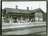 Stationshuset från tågsidan med resande.